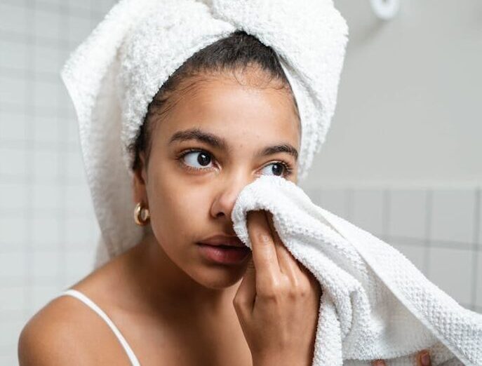 Woman enjoying a refreshing face care routine with towel at home. Perfect for beauty and lifestyle themes.